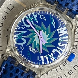 1993 NUEVO nunca usado Mint SLK100 Tone in Blue Musicall Musical Swatch Reloj correa de cuero azul temprana en caja con batería 34 mm azul púrpura