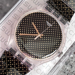 Swatch watch everyday 41mm black and gold NEW never worn in box called Gridlight running with a new battery fabulous swatch watch