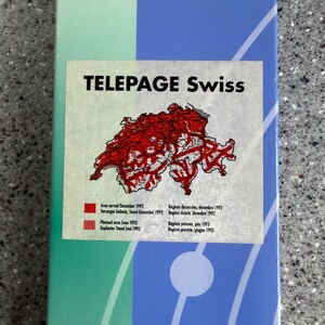 May include: A rectangular graphic with the text "TELEPAGE Swiss" and a red map of Switzerland. The graphic includes text in English, French, and Italian, detailing area served and planned area with dates.