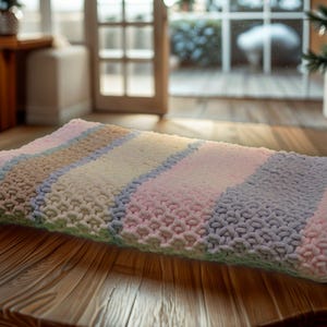 Colorful hand knitted baby blanket - soft and plush! Chunky and puffy yarn. Handmade blanket to create coziness and comfort. Pom pom blanket