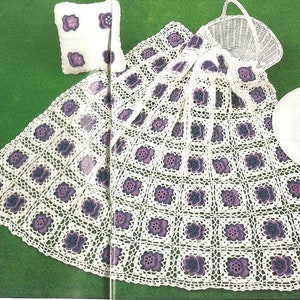 May include: A white crocheted throw blanket with a purple floral design. The blanket is made with a square stitch pattern and has a scalloped edge.