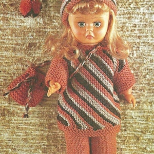 May include: A doll with blonde hair wearing a knitted outfit consisting of a long-sleeved tunic and pants in solid rust orange, paired with a matching striped pointed hat with a pom-pom and a small drawstring pouch in the same rust orange color.