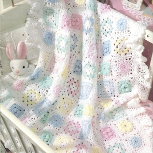 May include: A white crocheted baby blanket with a square pattern in pastel colours of pink, blue, green, and yellow.