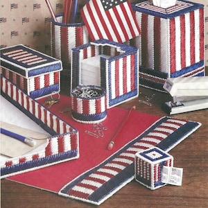 May include: A collection of desk accessories crafted from plastic canvas with a red, white, and blue striped pattern. The set includes a pencil holder, a tissue box cover, a note holder, a small round container, a tray, and a stamp dispenser.