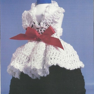 May include: A white crocheted bottle cover with a red bow and a black crocheted skirt. The bottle cover is designed to fit a standard-sized bottle.