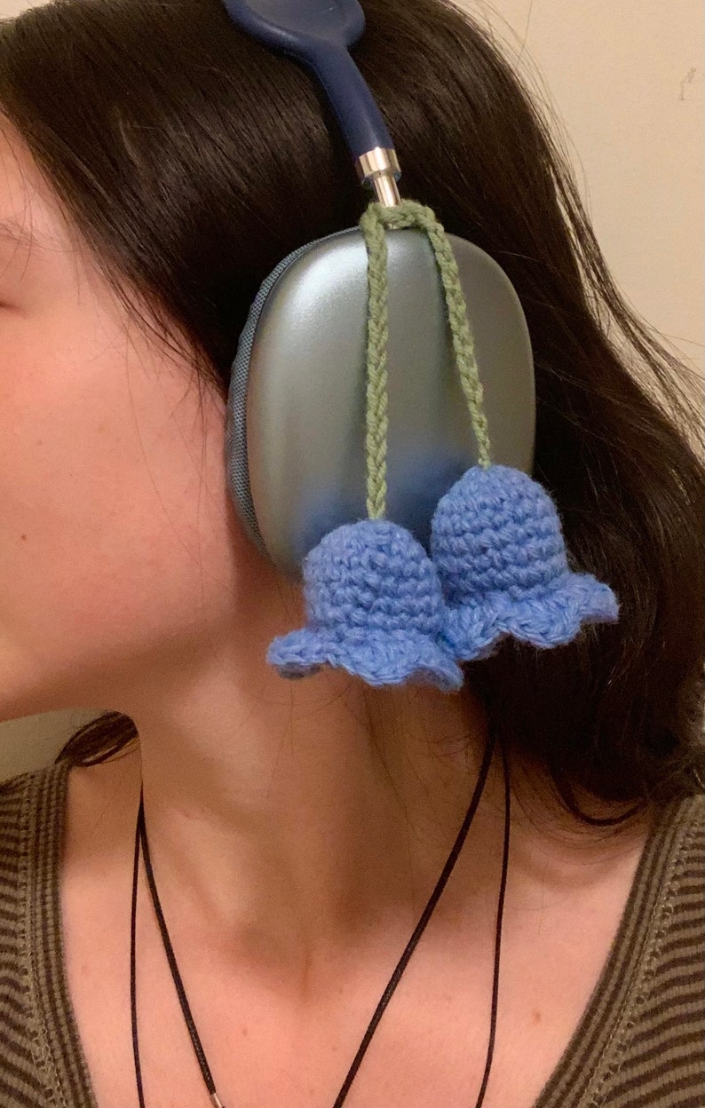 May include: Blue headphones with a light blue crocheted flower charm attached to each earcup.
