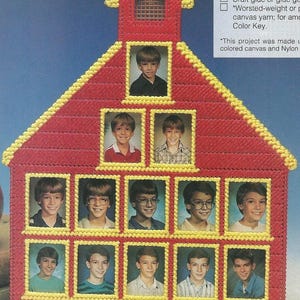 Könnte beinhalten: Ein rot-gelbes Schulhaus-förmiges Kunststoff-Leinwandprojekt mit gerahmten Fotos von Kindern. Das Schulhaus hat ein gelbes Dach und Zierleisten mit einem kleinen Fenster. Die Fotos zeigen Kinder in verschiedenen Outfits.