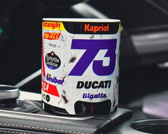 May include: White ceramic mug with a distressed, vintage racing design. The mug features a large purple number "73" with the word "DUCATI" and the sponsor logos "Kapriol", "Estrella Galicia", "Unibat", and "Gigetta".
