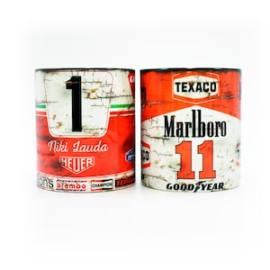 May include: Two vintage-style ceramic mugs with racing car designs. The first mug features the number "1" with the text "Niki Lauda HEUER" and various sponsor logos. The second mug features the number "11" with the text "Marlboro TEXACO GOOD YEAR".