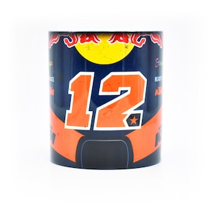 May include: A blue and orange ceramic mug featuring the number "12" and a star. The mug has a distressed look and includes the Red Bull logo.