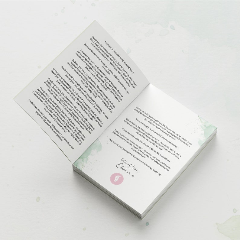 May include: An open book with a green watercolor design on the cover. The text on the page reads "This book is for anyone who has felt the overwhelming despair of an eating disorder. For those who have experienced the utter loneliness in the addiction, but you are not alone and you are strong enough."