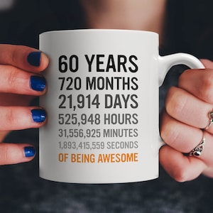 May include: White ceramic mug with black text that reads "60 Years 720 Months 21,914 Days 525,948 Hours 31,556,925 Minutes 1,893,415,559 Seconds of Being Awesome".