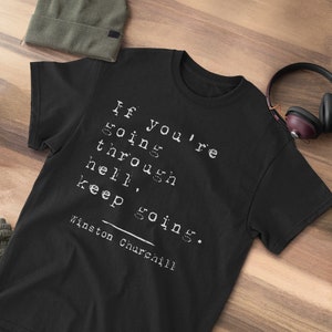 May include: Black t-shirt with white text that reads "If you're going through hell, keep going."  The text is attributed to Winston Churchill.