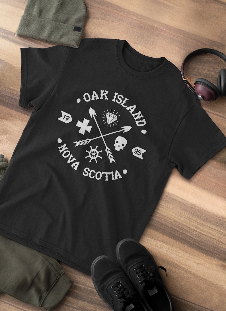 May include: Black t-shirt with a white graphic design featuring a compass, skull, arrows, and the text "Oak Island, Nova Scotia".