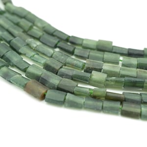 Puede incluir: Una hebra de cuentas de piedras preciosas de color verde oscuro, cada cuenta es un prisma rectangular con bordes ligeramente redondeados.