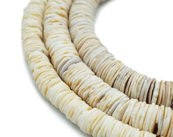 May include: A strand of white shell beads, each bead is a flat disc with a slightly irregular shape. The beads are strung together to form a long necklace.