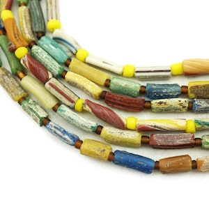 May include: Close-up of strands of colourful, cylindrical beads. The beads are a mix of colours including yellow, green, red, blue, and white. Each bead is separated by a small, yellow spacer bead. The beads have a rustic, textured appearance.