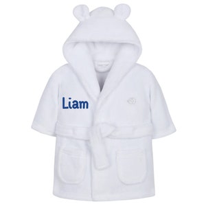 May include: White hooded robe with a blue embroidered name "Liam" and a small elephant design. The robe has a tie belt and pockets.