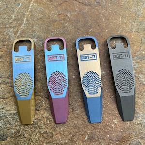 May include: Four different colored metal bottle openers with a fingerprint design and the text "DIGIT-TI" on each. The colors are gold, red, blue, and gray.