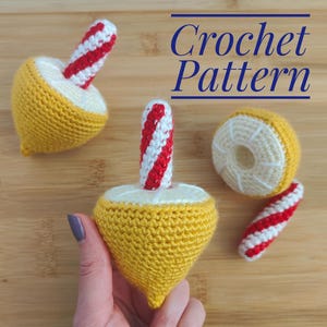 May include: Crocheted buoy pattern with yellow, white, and red yarn. The image shows several crocheted buoys, one held in a hand, and the text "Crochet Pattern" in blue.