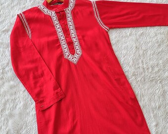 May include: A red long-sleeved shirt with white embroidery around the neckline and down the front. The shirt has a mandarin collar and a button closure.