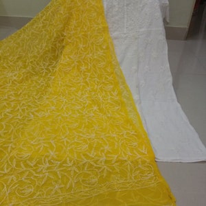 Op de afbeelding: Een witte geborduurde kurta met een gele geborduurde dupatta. De dupatta heeft een bloemenpatroon.