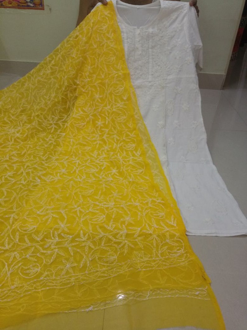 Op de afbeelding: Een witte geborduurde kurta met een gele geborduurde dupatta. De dupatta heeft een bloemenpatroon.