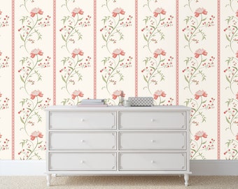May include: White dresser with six drawers against a wall with a pink and green floral wallpaper pattern.