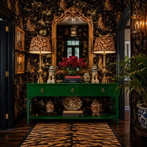 May include: A glossy emerald green console table with three drawers and a lower shelf, featuring gold ring pulls. It holds two brass lamps with leopard print shades, two ceramic foo dog statues, a vase of red flowers, and stacked books.
