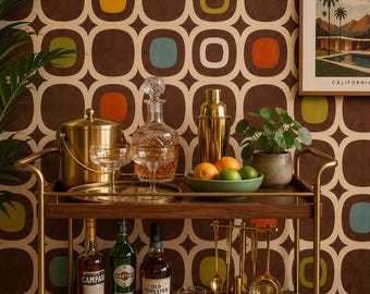 May include: A two-tiered wooden bar cart with a gold metal frame holding a gold ice bucket, a crystal decanter, two crystal coupe glasses, a gold cocktail shaker, a green bowl with citrus fruits, and a set of gold bar tools and liquor bottles.