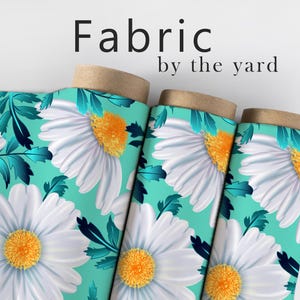 May include: Fabric rolls featuring a daisy floral pattern. The fabric has large white daisies with yellow centers and teal leaves on a teal background. The words "Fabric by the yard" are at the top.