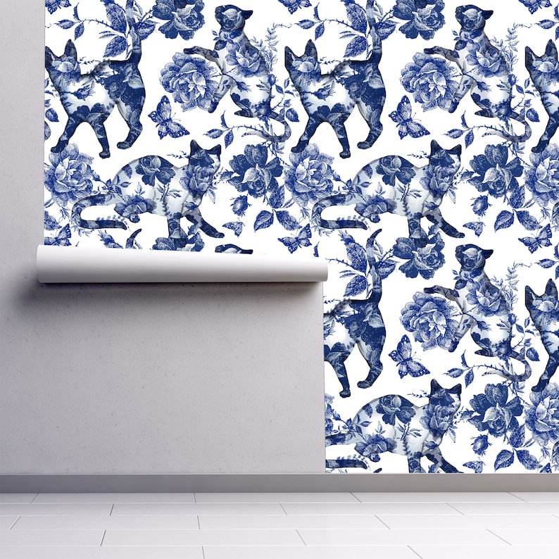 Blue cat and flower toile fabric peel and stick wallpaper on wall partially rolled up