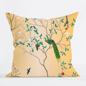 May include: A yellow throw pillow with a floral pattern featuring peacocks and birds. The pillow has a white background with green leaves and white flowers.