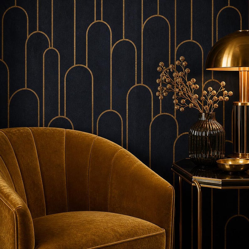 May include: An interior design scene featuring a mustard-colored velvet armchair, a black side table, and a gold-toned lamp. The background is a dark blue wall with a gold art deco pattern. A vase with decorative branches sits on the table.