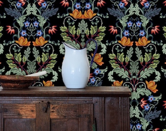 May include: A white pitcher with a blue rim sits on a dark wooden table in front of a black background with a repeating floral pattern. The pattern features orange, red, green, and blue flowers.