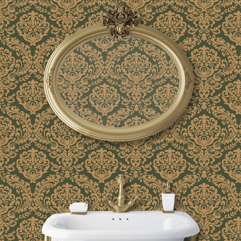 K&ouml;nnte beinhalten: Ein ovaler Spiegel mit goldenem Rahmen h&auml;ngt an einer mit gr&uuml;nem und goldenem Damast gemusterten Tapete bekleideten Wand &uuml;ber einem wei&szlig;en Porzellanwaschbecken mit einem goldenen Wasserhahn.