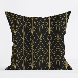 May include: Black and gold throw pillow with an Art Deco geometric pattern.