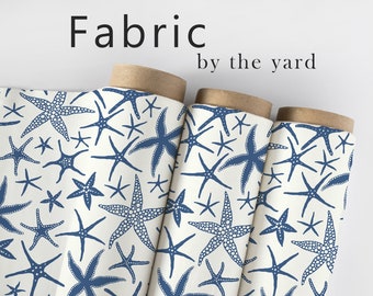 May include: Three rolls of white fabric with a blue starfish pattern. The fabric is labeled "Fabric by the yard".