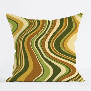Puede incluir: Una almohada decorativa con un patrón abstracto ondulado en tonos de verde, marrón y amarillo.