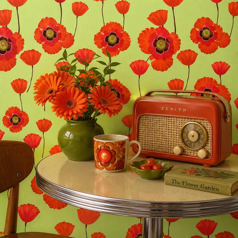 Puede incluir: Una escena retro con una radio Zenith roja, una taza floral y un jarr&oacute;n con flores naranjas. El fondo es una pared verde lima con dise&ntilde;os de amapolas rojas. Tambi&eacute;n hay un peque&ntilde;o cuenco de tomates y un libro titulado "The Flower Garden".