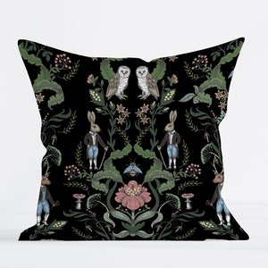 Peut inclure: Un coussin noir avec un motif de forêt fantaisiste représentant des hiboux, des lapins et des motifs floraux. Le motif est symétrique et présente un motif répétitif de hiboux, de lapins et de fleurs.