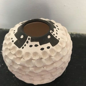 May include: White ceramic pot with black geometric designs and a textured surface.