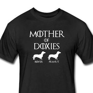 May include: Black t-shirt with white text that reads "Mother of Doxies" with two dachshund silhouettes below the text. The text "Rover" is below the left dachshund and "Peanut" is below the right dachshund.