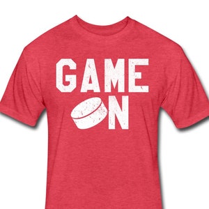 May include: Red t-shirt with white text that says "GAME ON" and a hockey puck graphic.