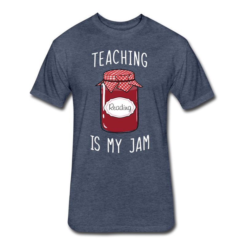 May include: A dark blue t-shirt with the text "TEACHING IS MY JAM" in white. A cartoon illustration of a jar of jam with a red lid and a white label that says "Reading" is in the centre of the shirt.