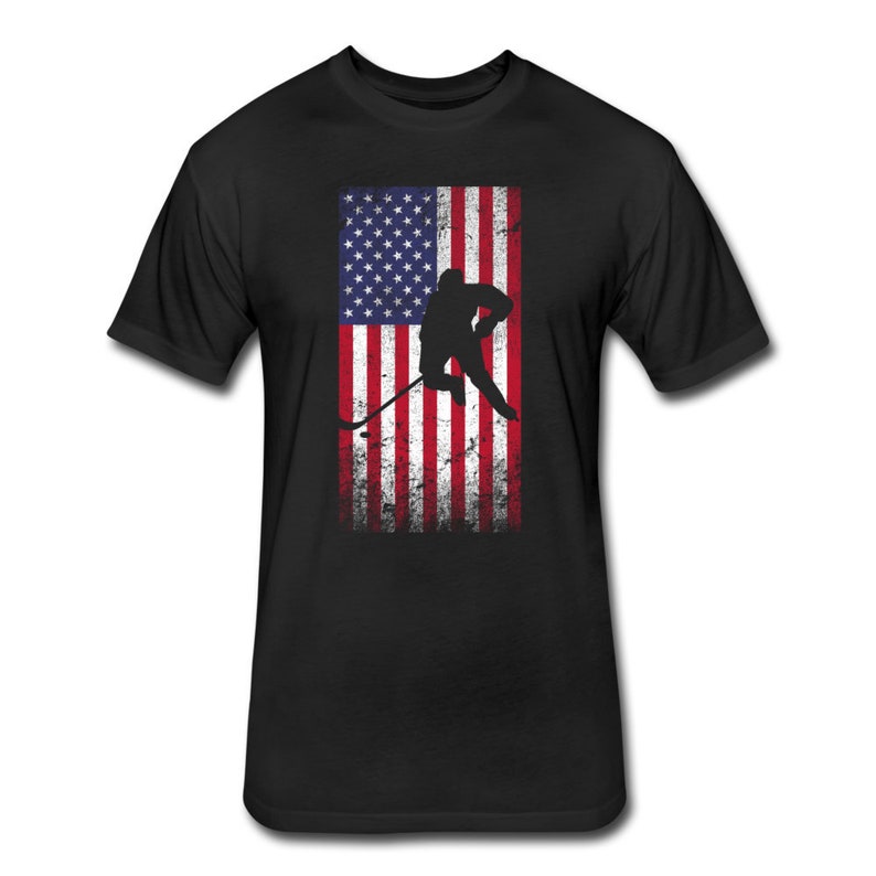 May include: Black t-shirt with a distressed American flag design and a silhouette of a hockey player skating with a stick.