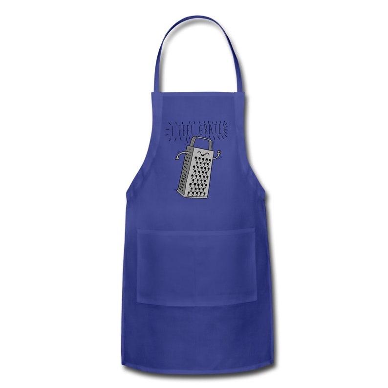 Pu&ograve; includere: Un grembiule da cucina blu con una tasca presenta un'illustrazione di un grattugia con un viso sorridente e il testo "I feel grate".