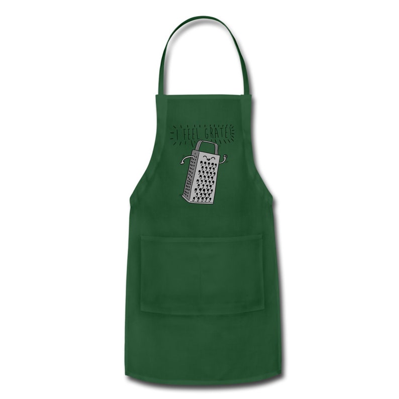 Pu&ograve; includere: Grembiule da cucina verde con una tasca e una grafica di una grattugia sorridente con il testo "I feel grate".