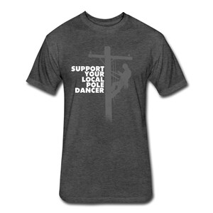 Puede incluir: Camiseta gris oscuro jaspeada con una silueta de una persona escalando un poste de electricidad. El texto "Support Your Local Pole Dancer" est&aacute; impreso en blanco en la camiseta.