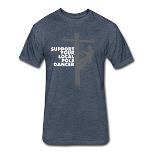 Puede incluir: Una camiseta azul oscuro con un gr&aacute;fico blanco de una silueta de una persona escalando un poste de electricidad. El texto "Support Your Local Pole Dancer" est&aacute; impreso en la camiseta.
